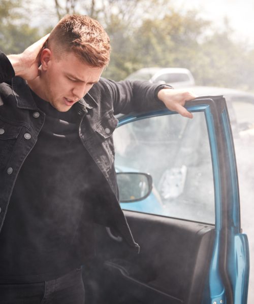 Male Motorist With Whiplash Injury In Car Crash Getting Out Of Vehicle